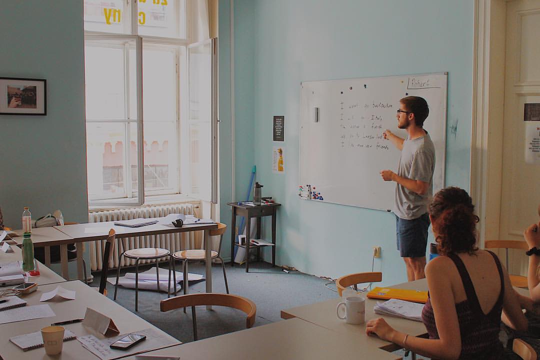 male teacher teaching English in blue room